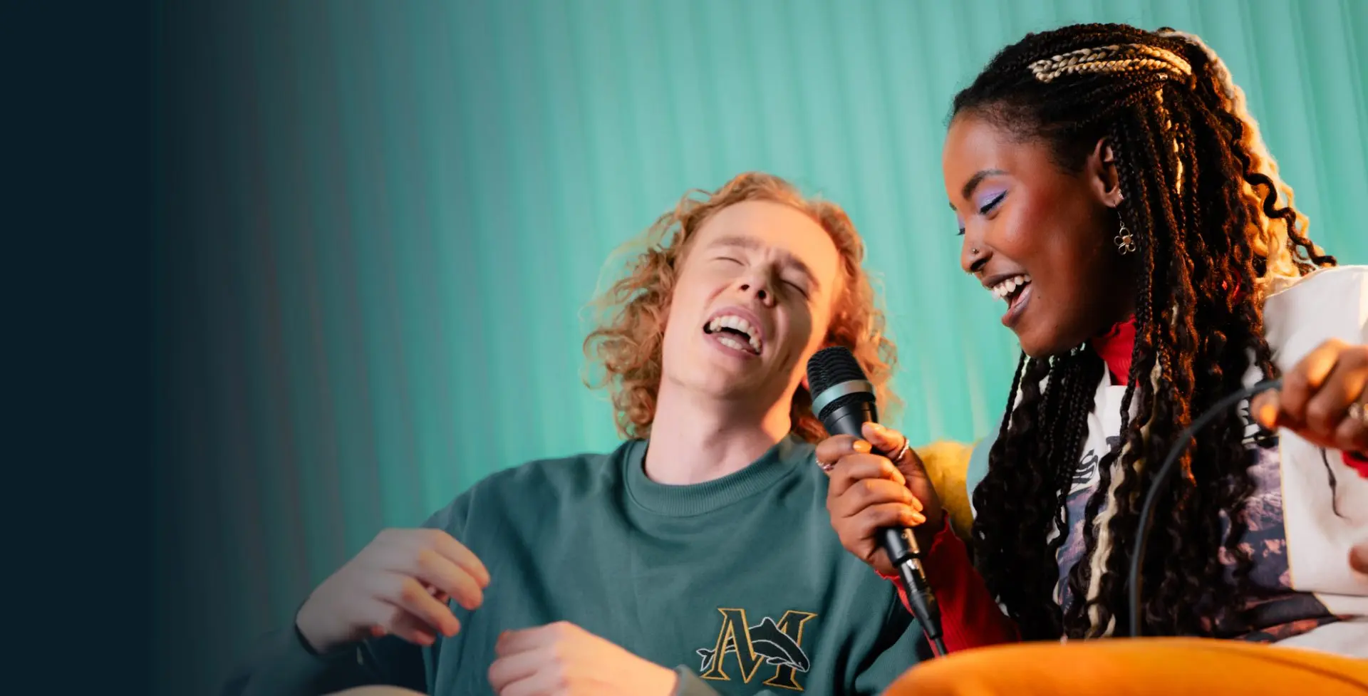 Two people singing into one microphone